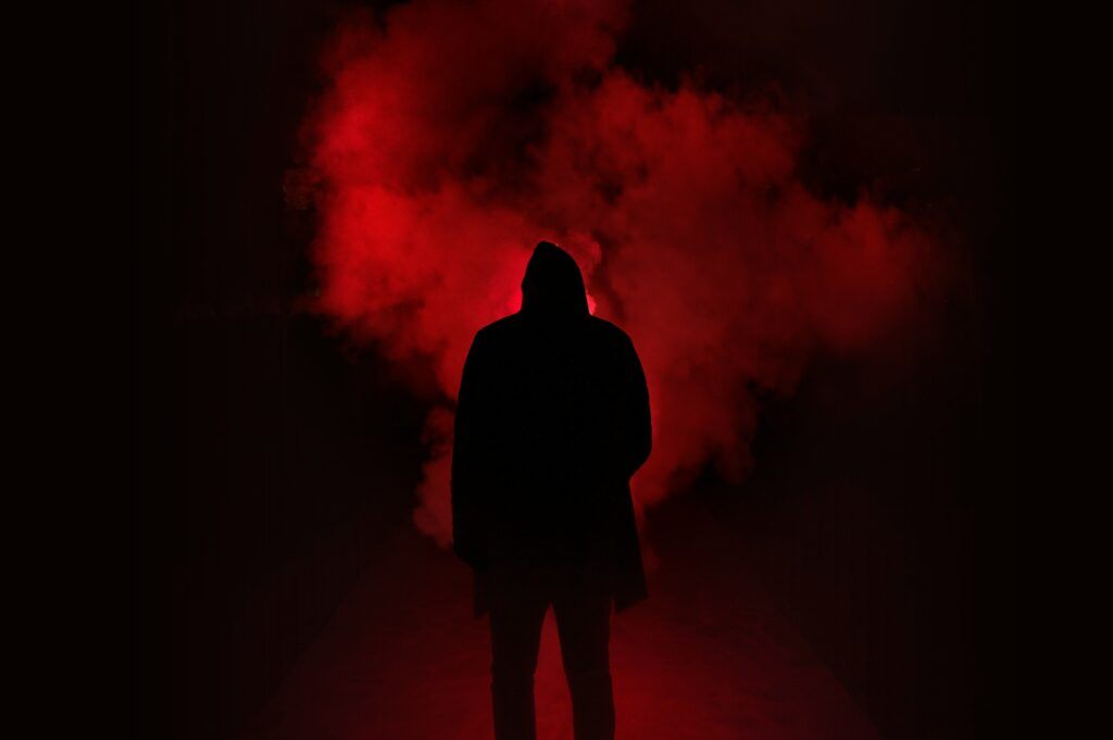 a dark figure standing in red fog to represent why horror is good for your brain